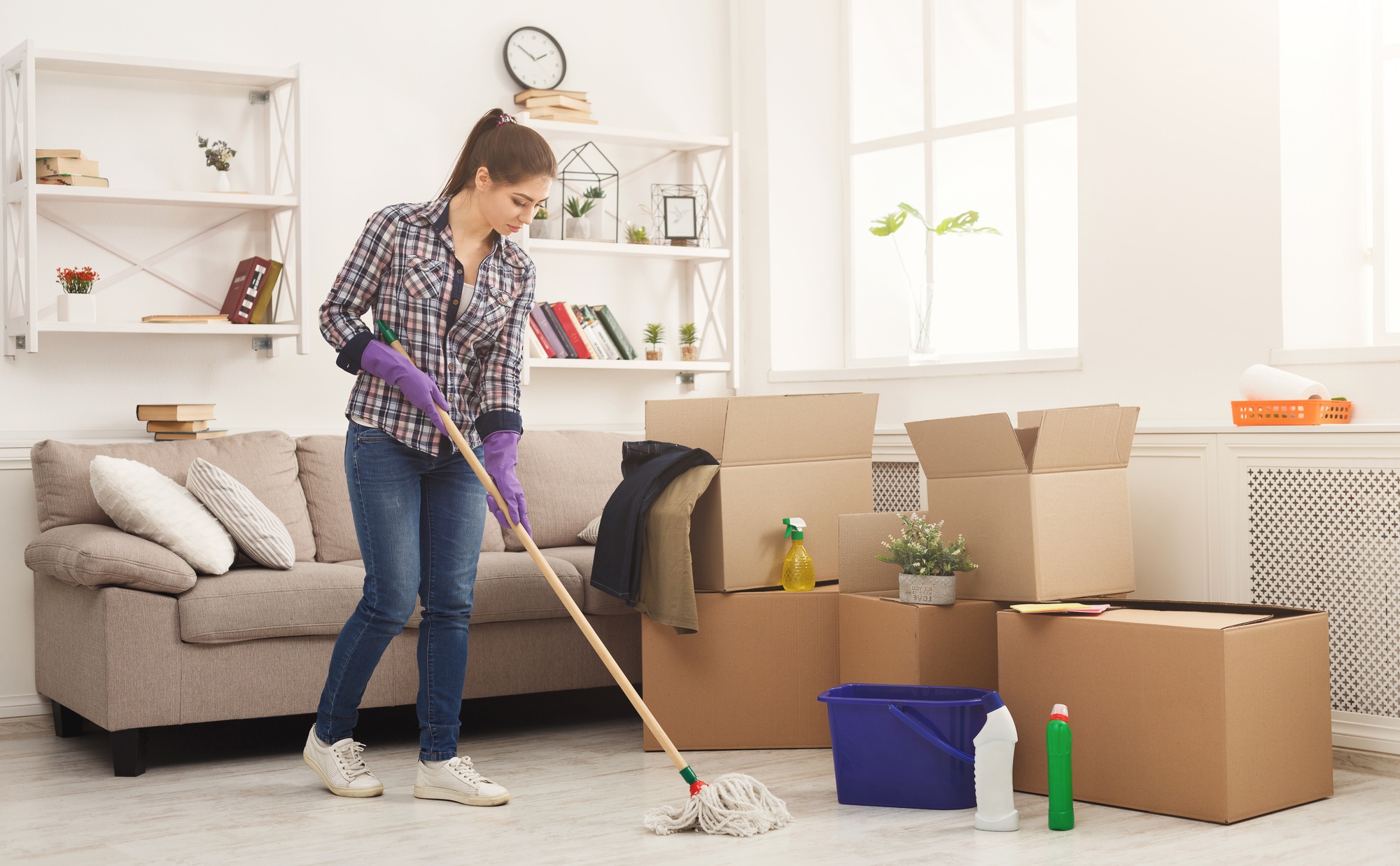 Young woman cleaning home with mop